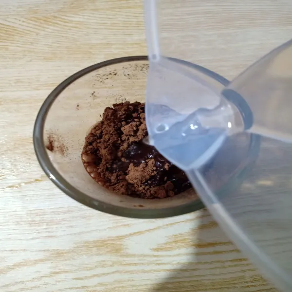 Dengan gelas lain, masukkan minuman coklat bubuk lalu seduh dengan 50 ml air panas, aduk hingga semua larut.