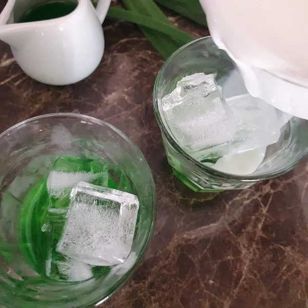 Siapkan gelas, masukkan larutan pandan, tambah es batu. Tuang larutan krimer, terakhir tuang espresso.