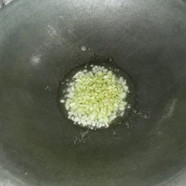 Tumis bawang putih hingga harum dan kekuningan.