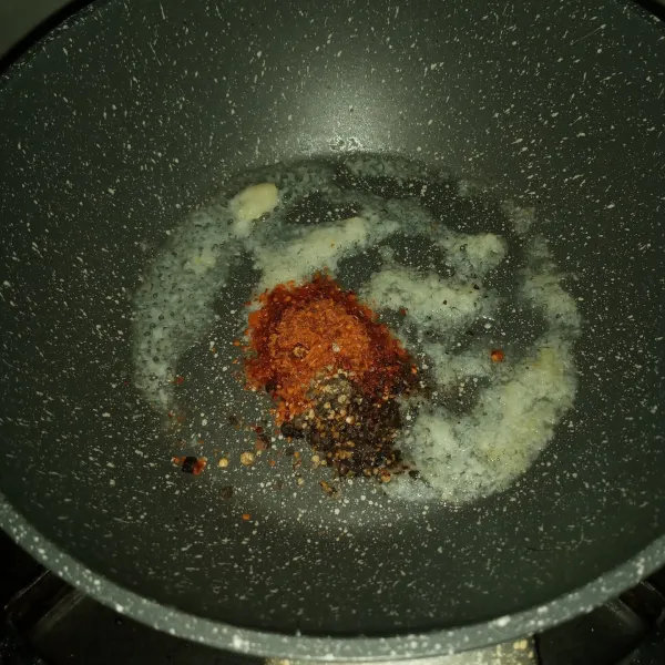 Panaskan minyak goreng dan minyak wijen. Tumis bawang putih dan jahe sampai wangi. Masukkan lada hitam dan chili flakes, tumis sebentar.