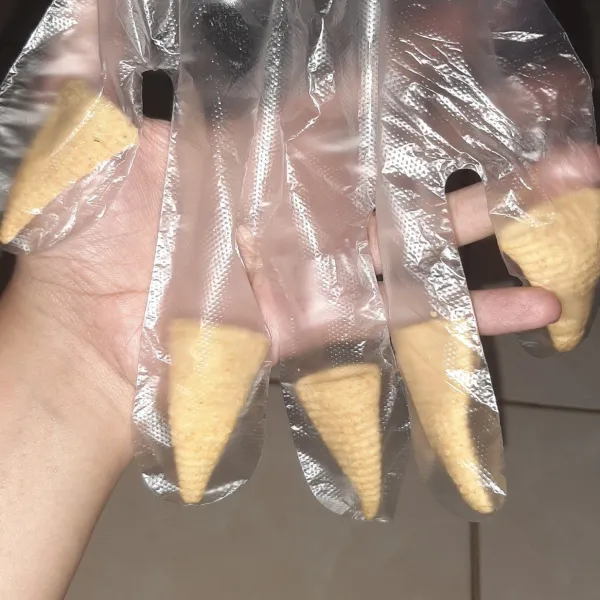 Masukkan snack kerucut ke sarung tangan agar seperti kuku.