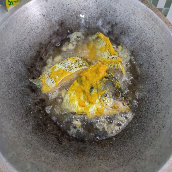 Panaskan minyak goreng, goreng ikan yang sudah dibumbui dengan api sedang.
