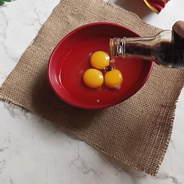 Campurkan kecap asin dengan telur.