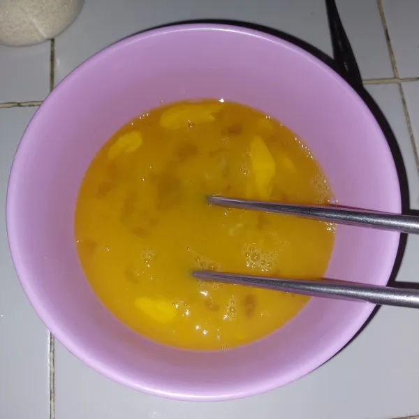 Aduk menggunakan sumpit yang dilebarkan agar tidak menimbulkan gelembung untuk hasil tamagoyaki yang halus.