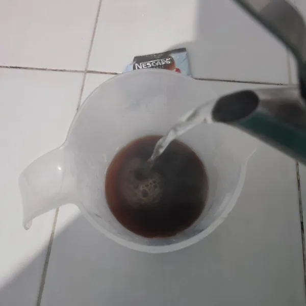 Seduh kopi dengan air panas, kemudian masukkan cetakan es batu. Masukkan frezeer dan biarkan beku.