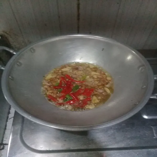 goreng kacang tanah sampai setengah matang lalu masukkan bawang merah, bawang putih dan cabai. Aduk-aduk sambai matang, sisihkan.