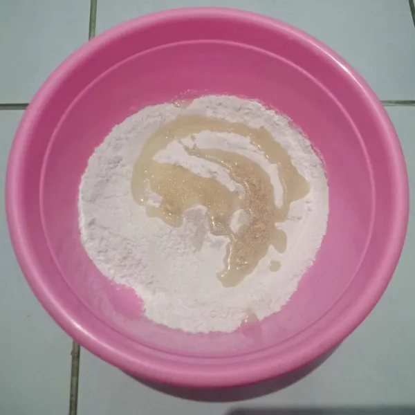 Tambahkan ragi, gula yang sudah dilarutkan dengan air, dan baking powder setelah itu, aduk rata.