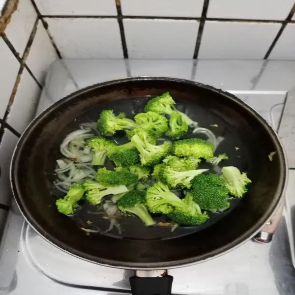 Masukkan brokoli dan 150 ml air. Tutup wajan sebentar sekitar 5 menit sampai brokoli matang.
