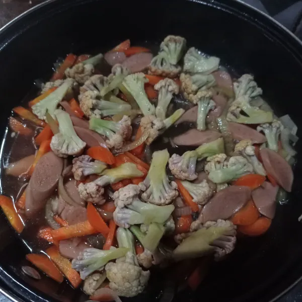 Masukkan semua bahan capcay kecuali irisan daun bawang, aduk rata dan masak sampai sayuran matang, cek rasa.