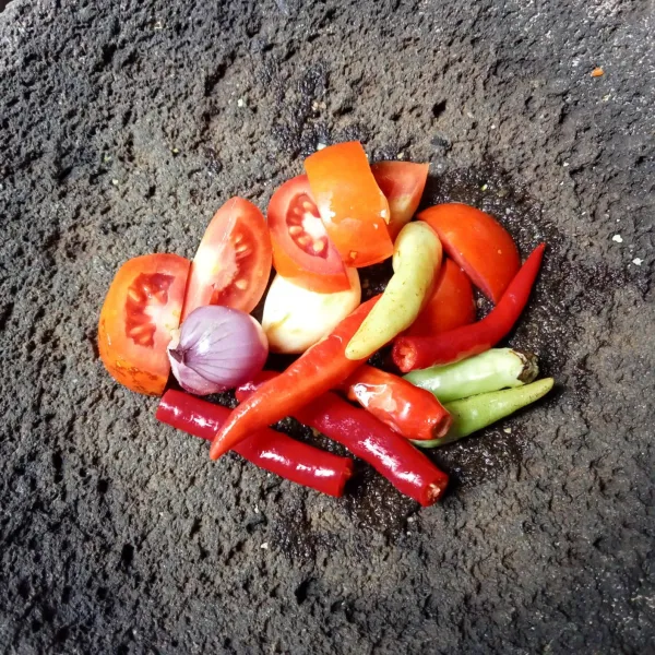 Siapkan cabai, tomat, bawang merah, dan bawang putih di cobek.
