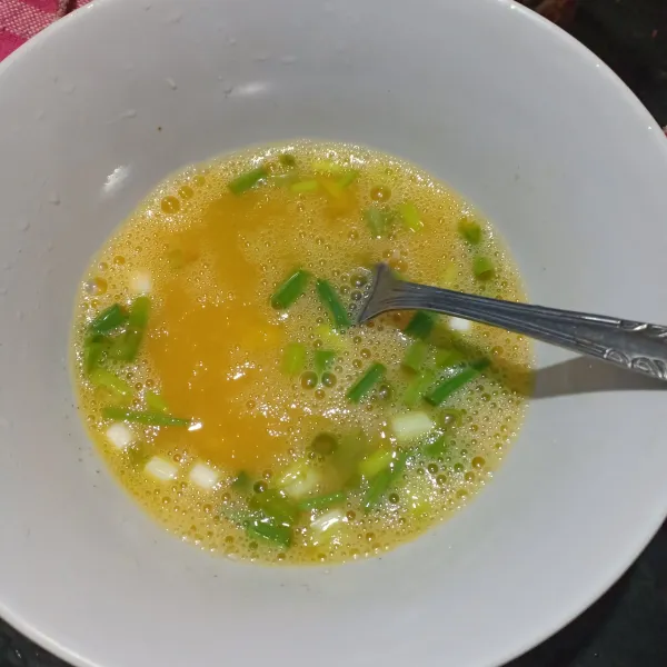 Kocok telur campur dengan garam, lada bubuk, dan daun bawang.