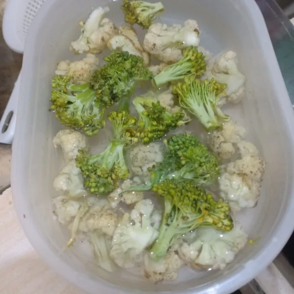 Potong brokoli dan kembang kol lalu cuci.