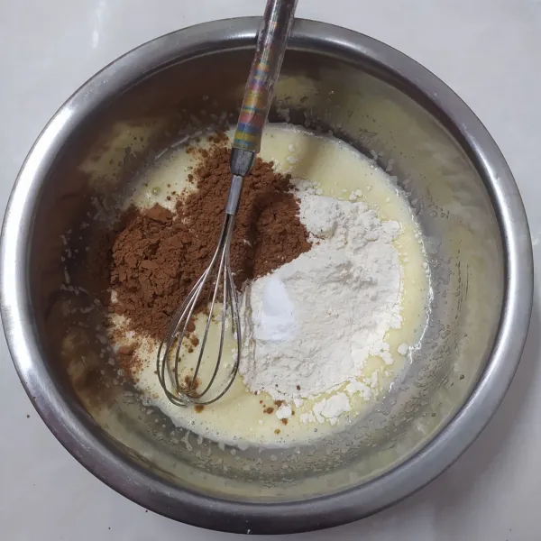 Tambahkan terigu, bubuk coklat dan baking powder. Aduk asal tercampur.