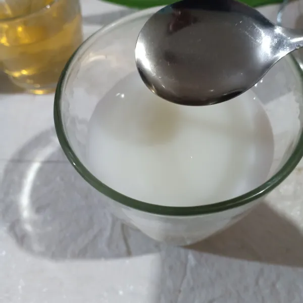 Di gelas saji, larutkan krimer dengan air hangat dan tambahkan air madu.