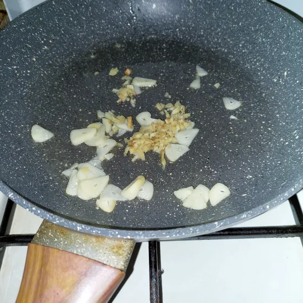 Tumis bawang putih hingga harum lalu masukkan jahe cincang, tumis merata.