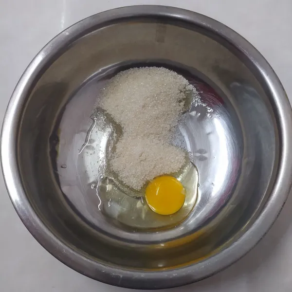 Dalam wadah, masukkan telur, gula pasir dan essence vanila. Aduk sampai tercampur rata dengan wishker dan gula larut.