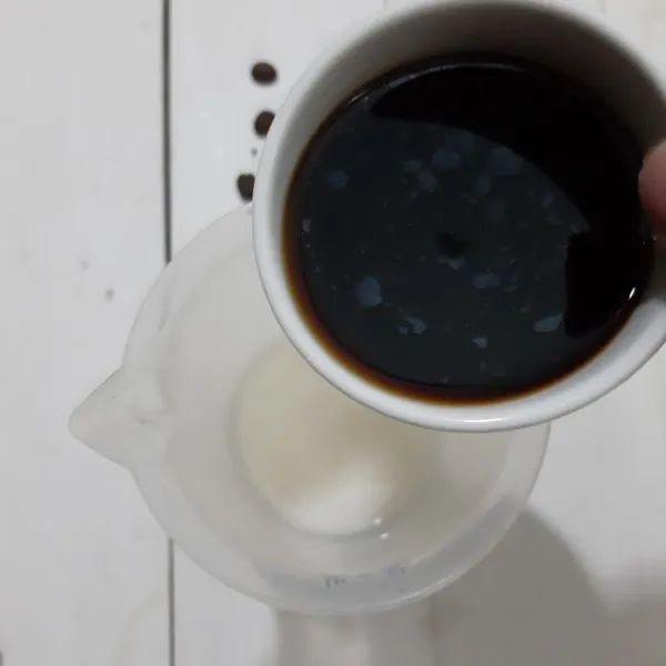 Letakkan susu evaporasi dalam gelas takar kemudian tuang kopinya.