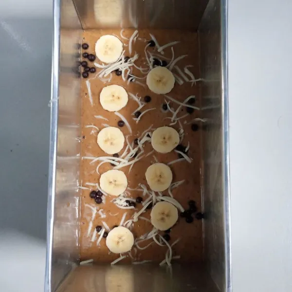 Tuang adonan ke dalam loyang ukuran 20x10 yang sudah diolesi baking pepper. Kemudian beri topping diatasnya.