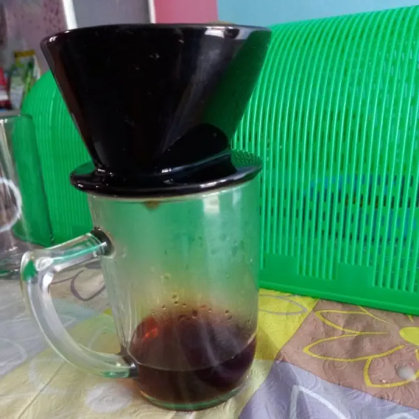 Siram kopi tubruk dengan air panas menggunakan gelas khusus penyaring kopi