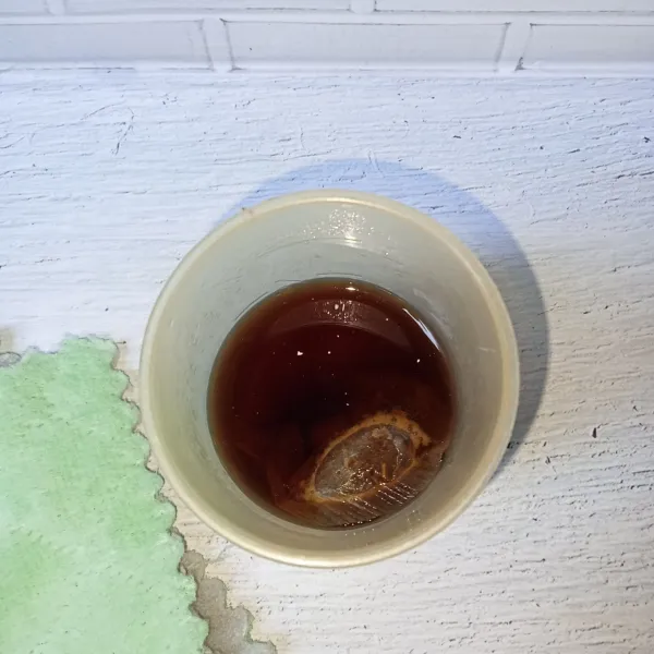 Seduh teh dengan air panas, lalu tambahkan gula pasir dan aduk rata. Biarkan hingga dingin.