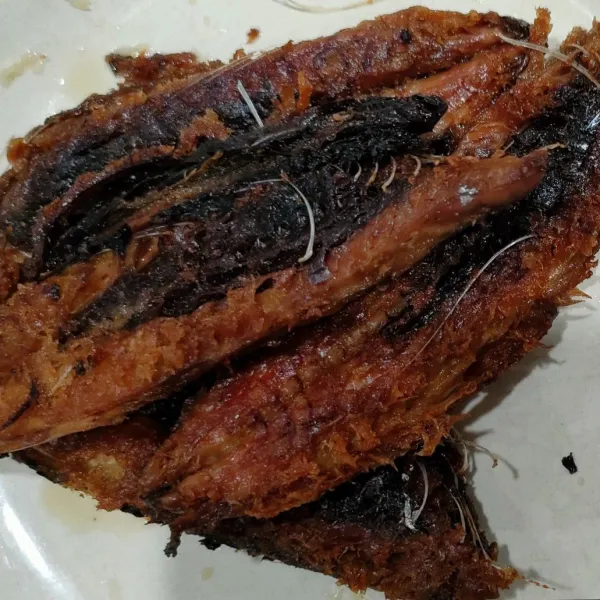 Cuci bersih ikan, belah jadi 2, lalu goreng garing.