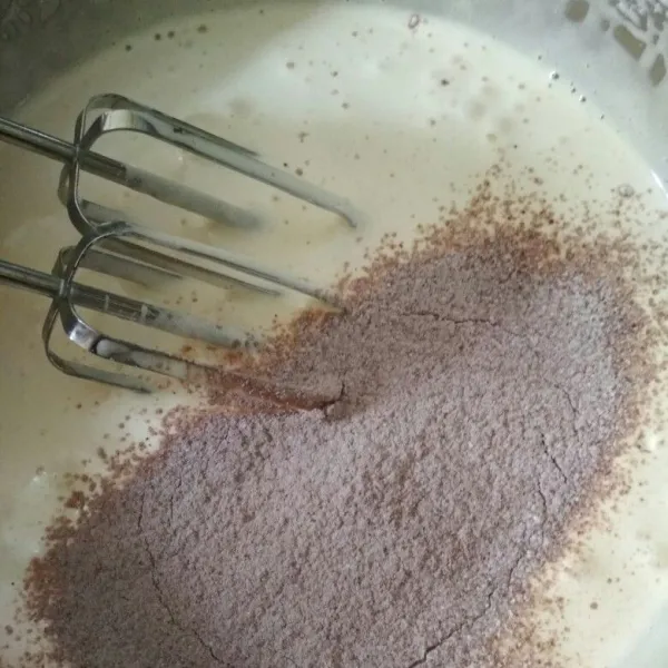 Masukkan bertahap tepung terigu dan coklat bubuk yang sudah diayak, mixer dengan speed rendah.