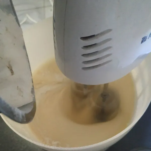 Masukkan tepung terigu serbaguna dan baking powder yang sudah diayak sedikit demi sedikit sambil di mixer.