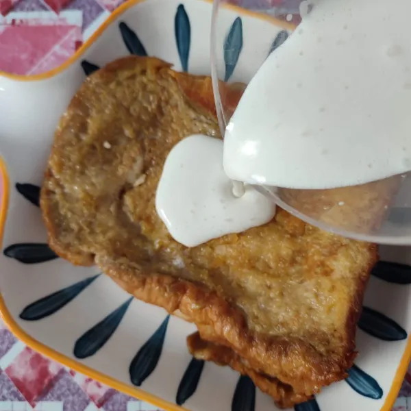 Tuang richcreme di atas roti tawar panggang, taburi dengan coklat bubuk atau milo.