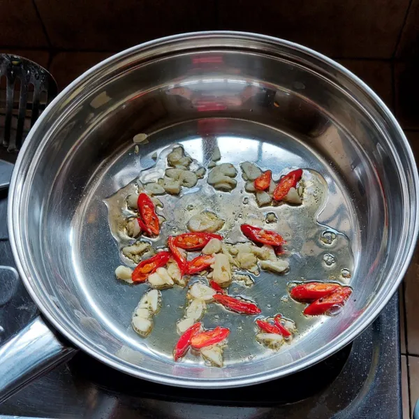 Panaskan minyak goreng, tumis bawang putih dan cabai sampai wangi.