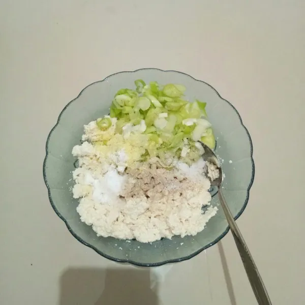 Lalu masukkan daun bawang, bawang putih bubuk, merica bubuk, kaldu bubuk, dan garam. Aduk hingga tercampur rata.