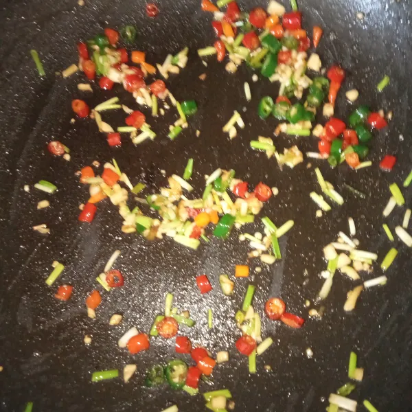 Masukkan cabai dan daun bawang, lalu tumis sebentar lagi. Tambahkan garam, gula pasir, dan merica bubuk, aduk rata.