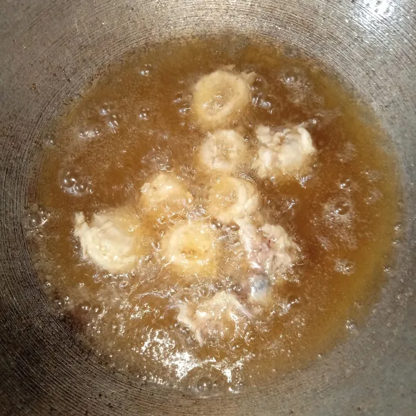 Panaskan minyak goreng, lalu goreng cumi-cumi satu per satu hingga kekuningan, kemudian tiriskan.