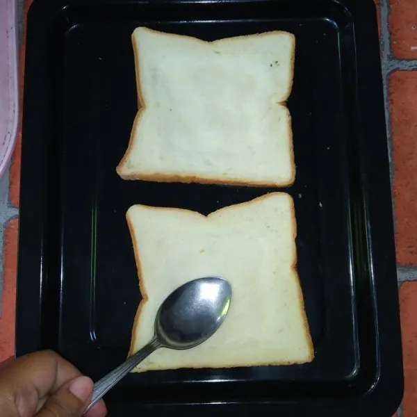 Siapkan roti tawar, buat cekungan di bagian tengah roti dengan cara menekan pakai sendok.