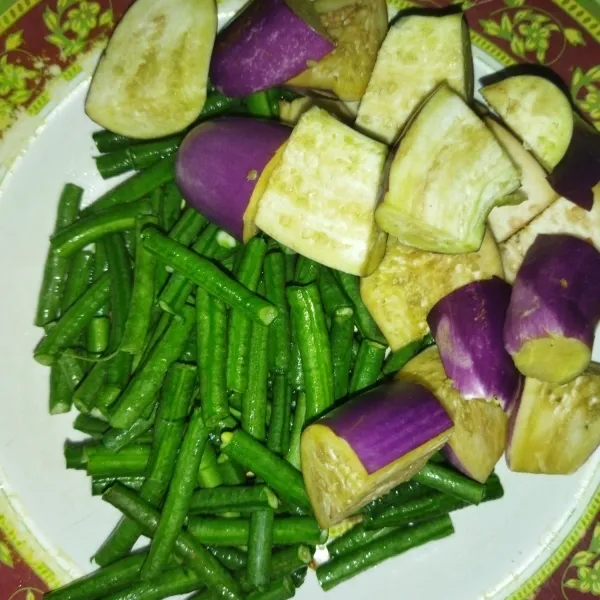 Siapkan sayuran yang sudah dicuci, lalu potong-potong kacang panjang dan terong.