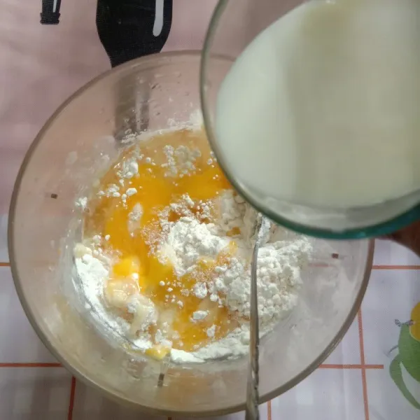 Siapkan wadah. Masukkan tepung terigu, telur, garam, minyak aduk rata. Masukkan susu perlahan sedikit demi sedikit. Aduk hingga adonan mulus tidak bergerindil.