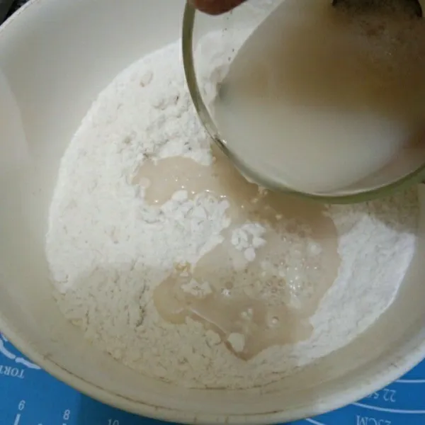 Dalam wadah campur tepung terigu, garam, dan minyak goreng. Kemudian tuang larutan ragi, aduk dan uleni selama 3 menit.