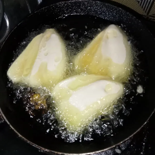 Lalu goreng pisang hingga matang dan keemasan, lalu angkat dan tata di piring, kemudian sajikan.