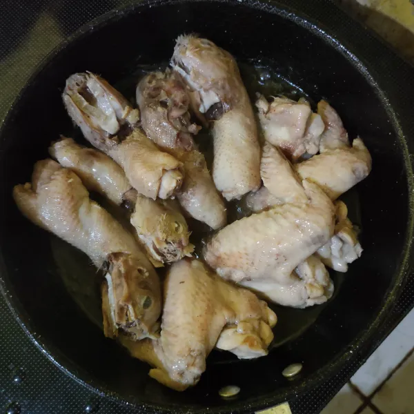 Goreng sayap dan kepala ayam dengan sedikit minyak hingga matang.
