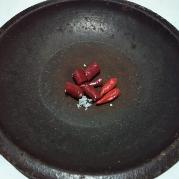 Haluskan cabai merah, cabai rawit, dan garam.