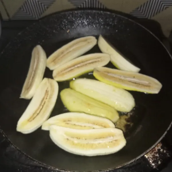 Kupas pisang dan belah dua, panaskan margarin dan letakkan pisang di atasnya, bolak-balik pisang hingga sedikit kecokelatan, lalu sisihkan.