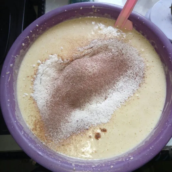 Masukkan pisang, vanila dan minyak, aduk rata. Kemudian masukkan tepung terigu, kayu manis bubuk, baking powder dan susu bubuk sambil diayak. Mixer dengan speed rendah sampai tercampur rata.
