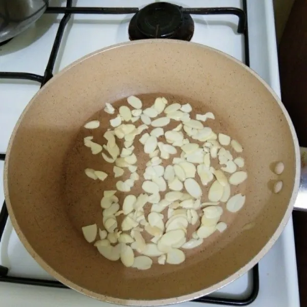 Panggang kacang almond di atas teflon dengan api kecil hingga berubah warna, lalu sisihkan.