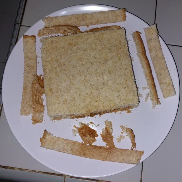 Buang pinggiran roti, potong dengan ukuran 3cm x 2cm sehingga mendapatkan 12 potong dari 2 lembar roti.