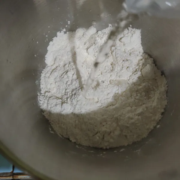 Tuang air hangat, aduk rata lalu uleni hingga kalis. Bisa menggunakan mixer, namun krn banyak menggunakan terigu protein rendah, kalisnya tidak bisa elastis banget.