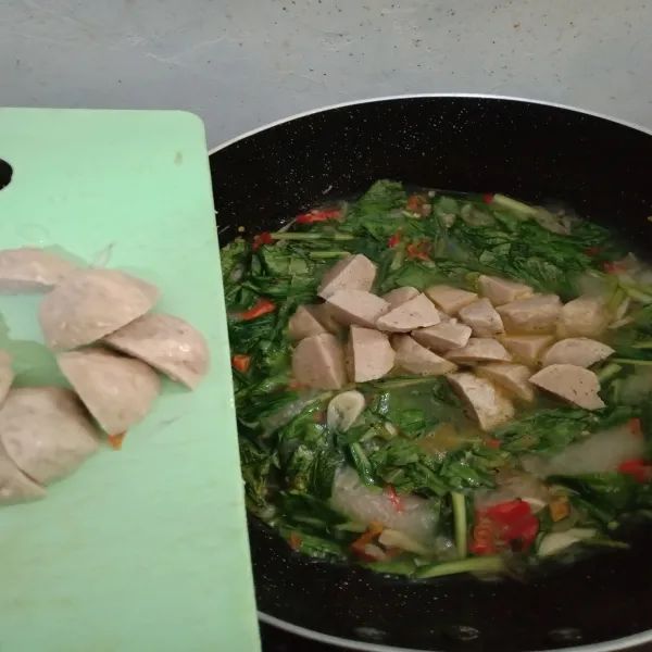Setelah air dimasukkan, perlahan masukkan bakso yang sudah dipotong menjadi 4 bagian.