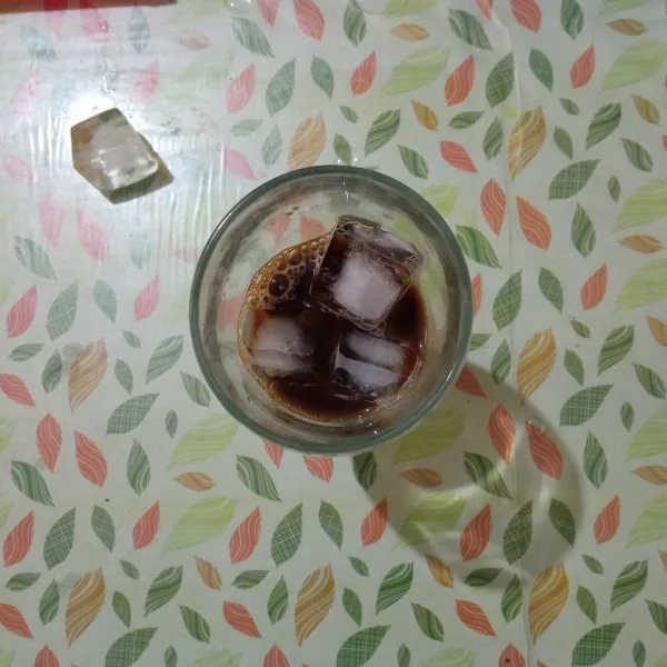 Larutkan kopi dengan air panas, lalu masukkan es batu kedalam gelas saji.