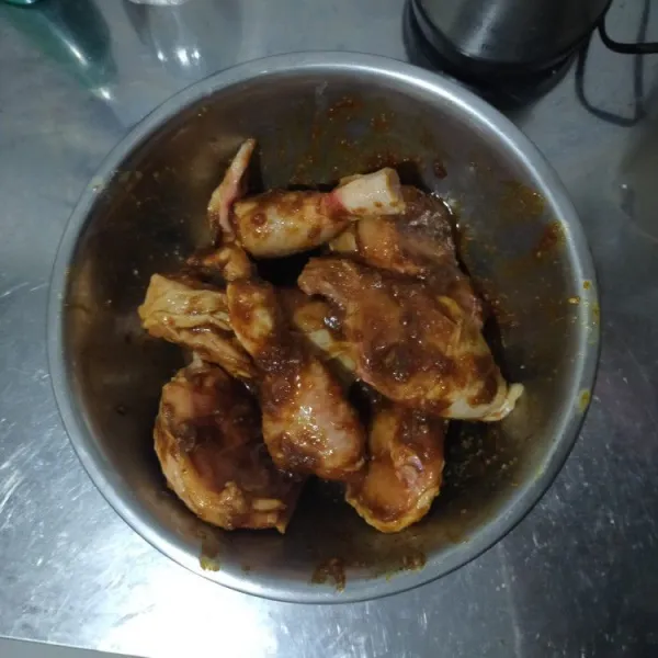 Lumuri ayam dengan campuran bumbu.