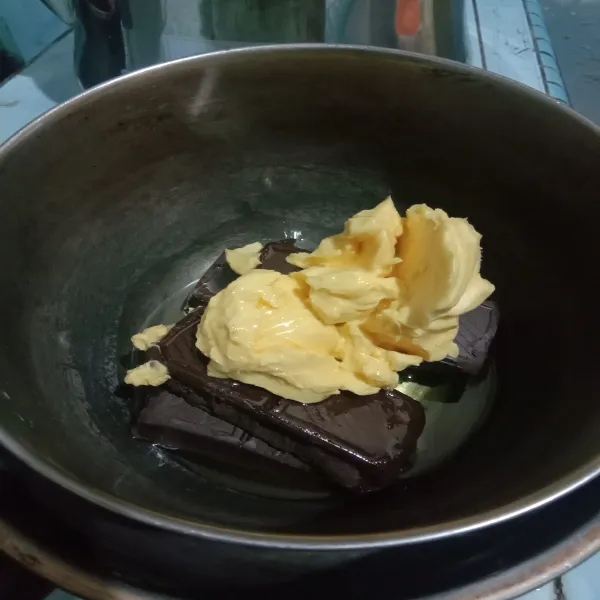 Masukkan dark cooking cokelat iris-iris terlebih dahulu, mentega dan minyak goreng kedalam panci. Lalu di tim diatas panci berisi air, hanya sampai semua meleleh saja. Sisihkan.