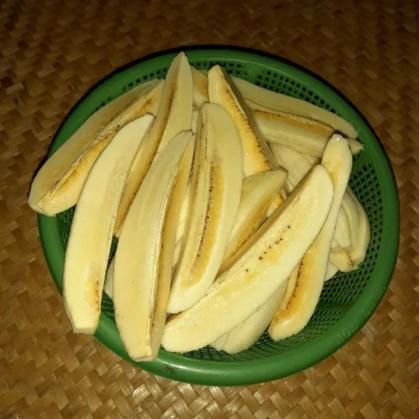 Kupas pisang, lalu potong pisang menjadi empat bagian.