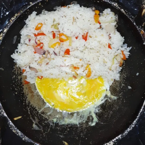 Pecahkan telur. Aduk rata dengan nasi.
